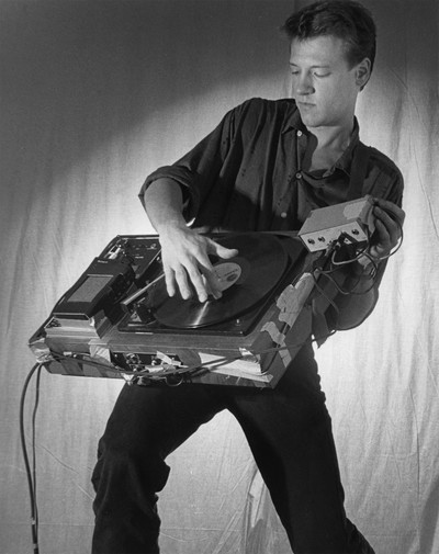 Christian Marclay playing his Phonoguitar, 1983. Photograph by Steven Gross, courtesy of Christian Marclay Studio, London. - © Oracles: Artists’ Calling Cards